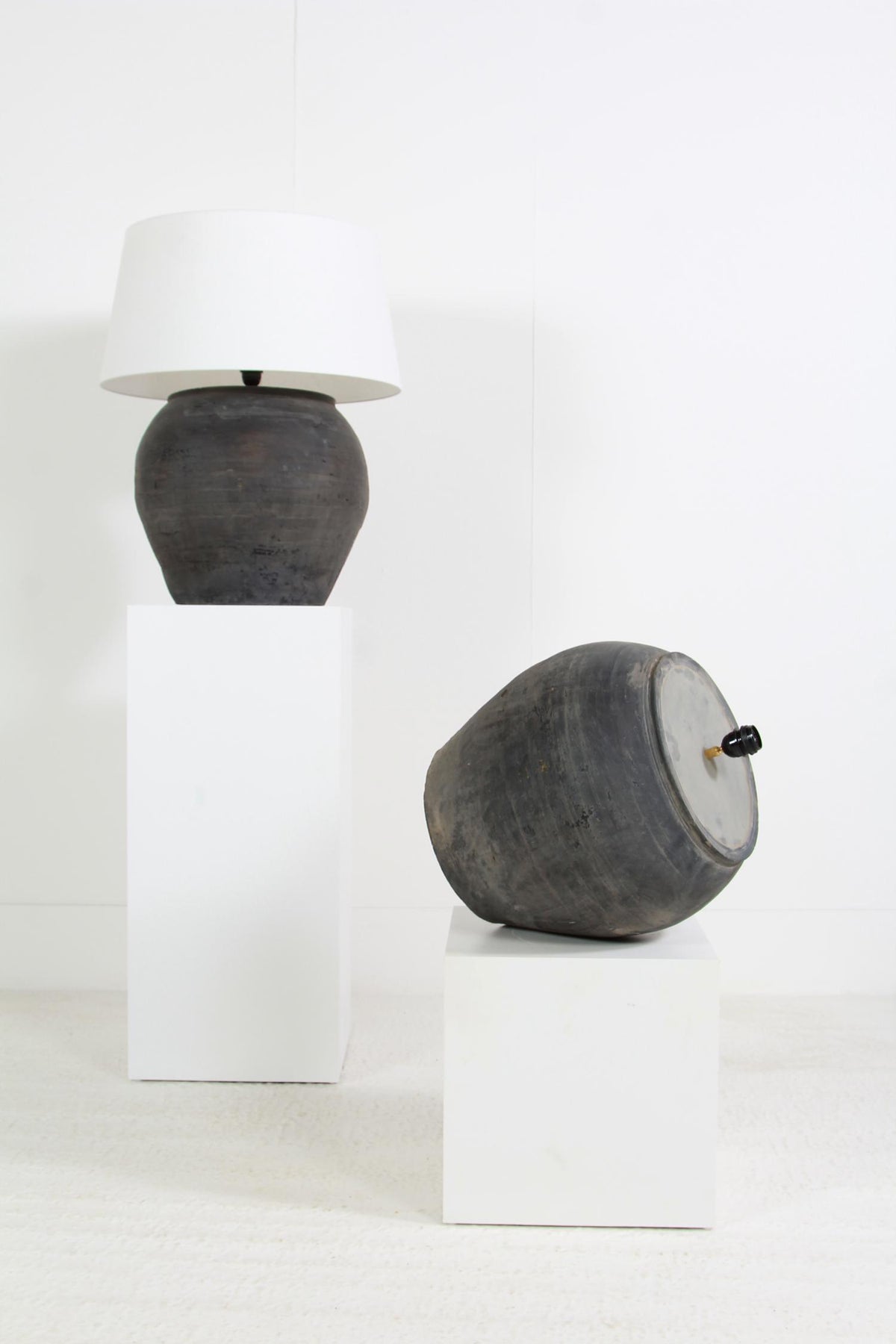 NEAR PAIR OF HUGE CHINESE BLACK POTTERY LAMPS WITH WHITE LINEN SHADES