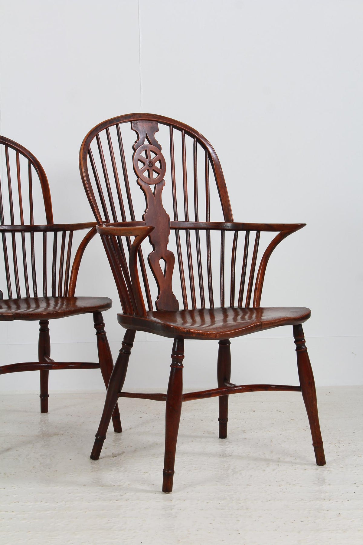 An Exceptionally Fine Pair of Yew Wood Wheel Back Windsor chairs