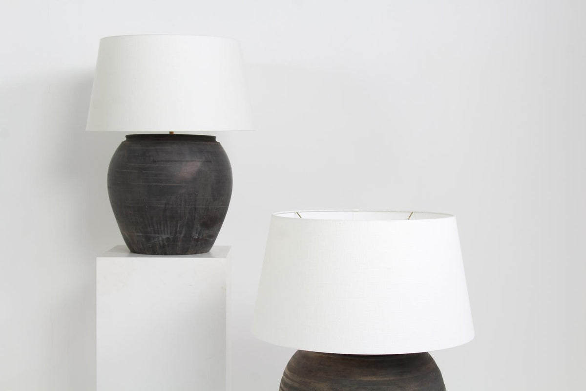 NEAR PAIR OF XL CHINESE BLACK POTTERY LAMPS WITH WHITE LINEN DRUM SHADES