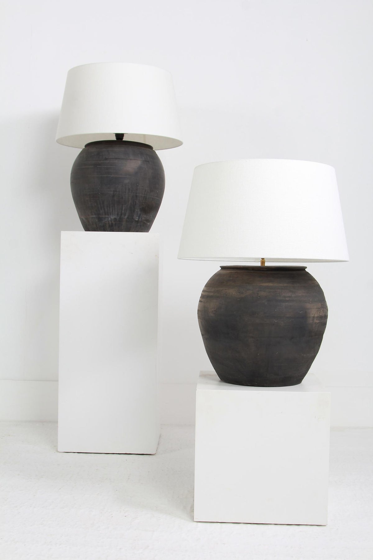 NEAR PAIR OF XL CHINESE BLACK POTTERY LAMPS WITH WHITE LINEN DRUM SHADES